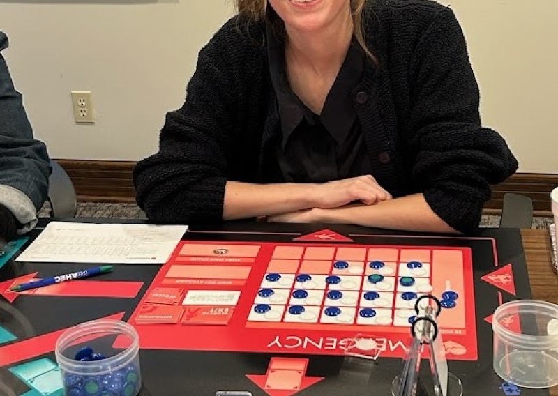 Elsa Romero is pictured sitting in front of the game board.