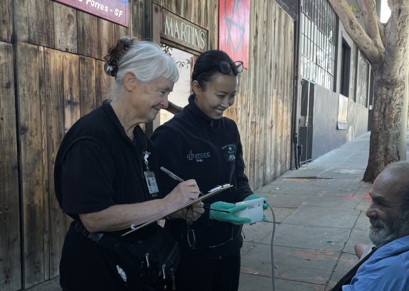 Emily J is seen doing outreach with a patient together with the SOS Resident Nurse.