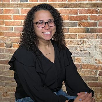 Madeira is sitting in front of a brick wall.