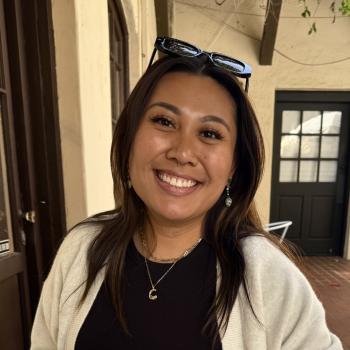 Charlene is facing the camera and smiling. 