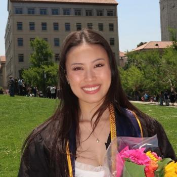 Emily Jiang is in the center of the frame, smiling at the camera.