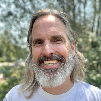 Jeffrey faces the camera and is smiling at the camera.