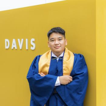 Angel poses in graduation regalia at UC Davis.