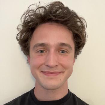 Jack Baker is in the middle of the frame, smiling at the camera.