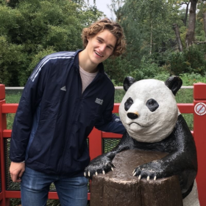 NHC PGH member Nate smiling posing with a panda statue