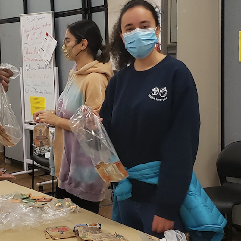 Leora packing food in bags.