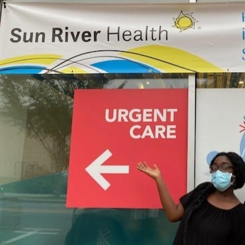 Kendra posing in front of her host site building.