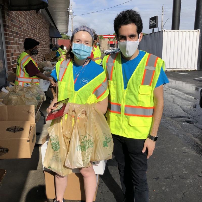 Performing outside service at a drive-through food giveaway event with another AmeriCorps Member. 