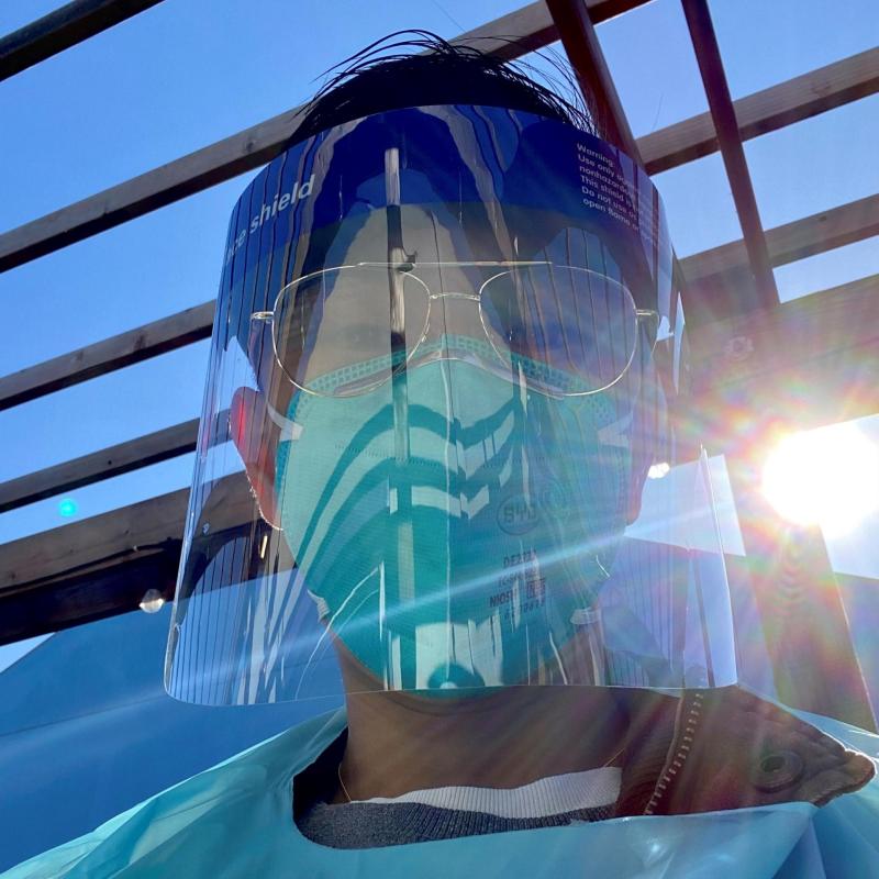 NHC SF AmeriCorps Member Christian Chen during service. Christian is wearing a facemask, faceshield, and medical gown.
