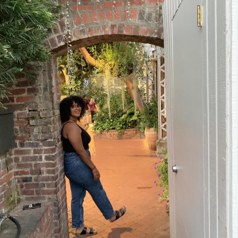 NHC PGH member Nanno smiling, leaning against an outside door