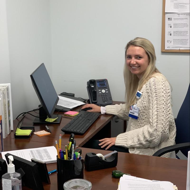 Olivia is pictured here at her host site working on Medicaid applications for families.