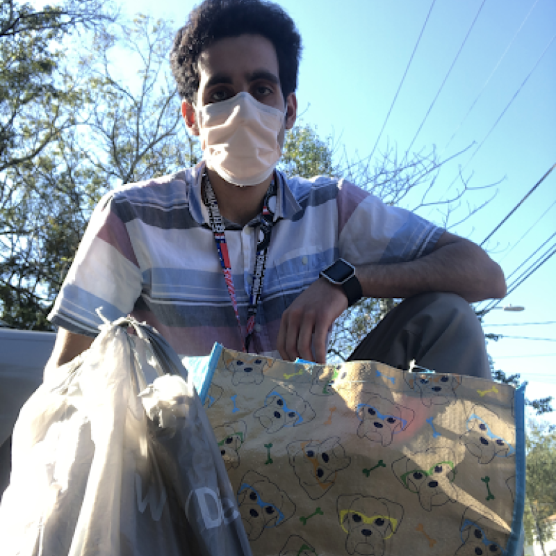 Armaan with a Thanksgiving basket and turkey that he is about to deliver to a client.