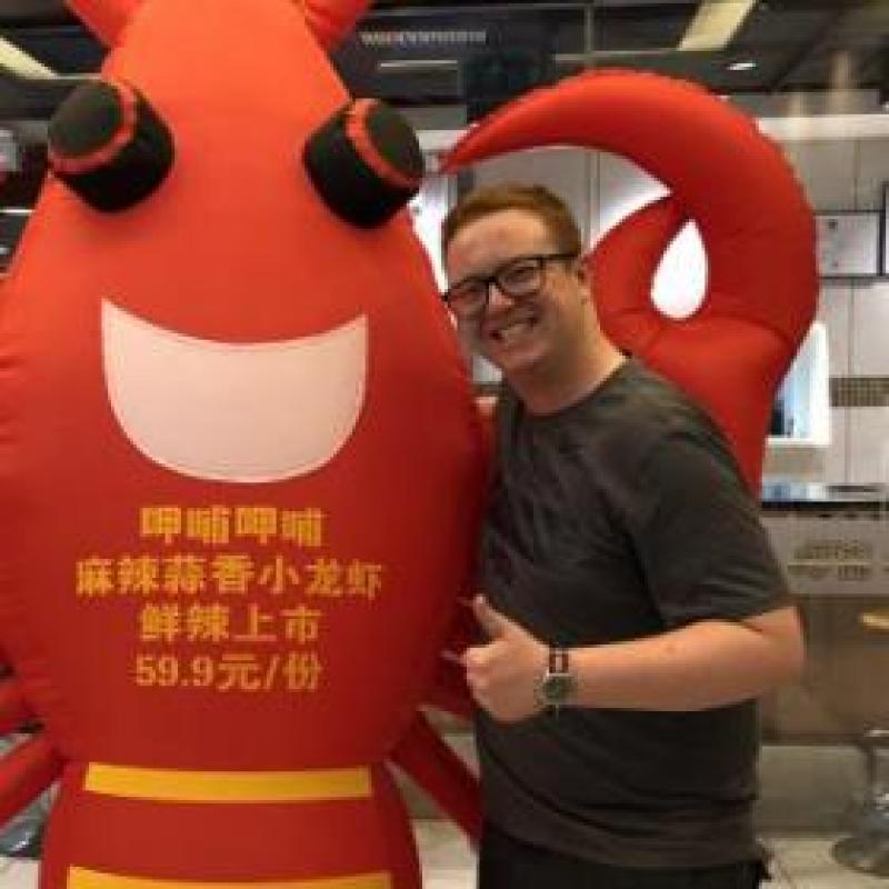 NHC PGH member Daniel smiling and thumbs up next to lobster mascot