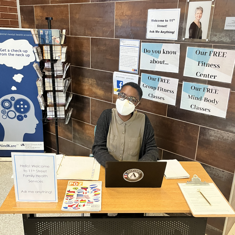 Jessica sitting at a  table advertising free wellness classes