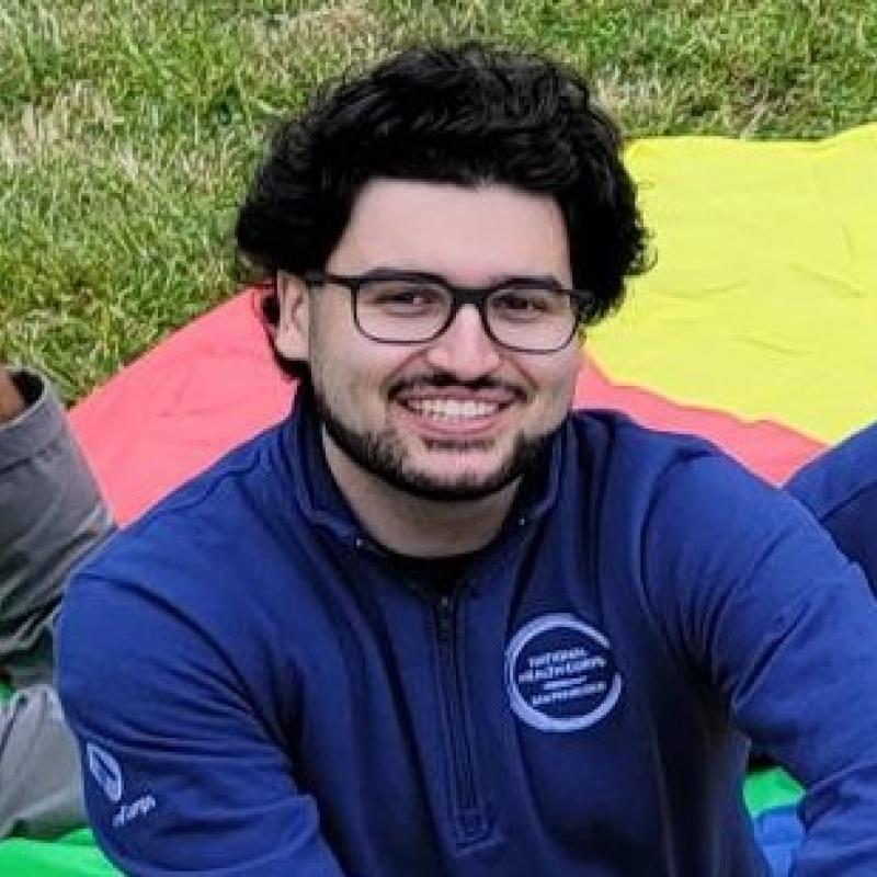 Jack is sitting at the center of the frame, smiling at the camera.