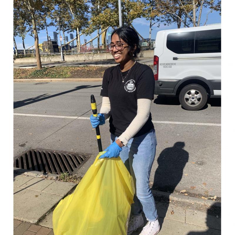 Anisha participates in a litter cleanup.