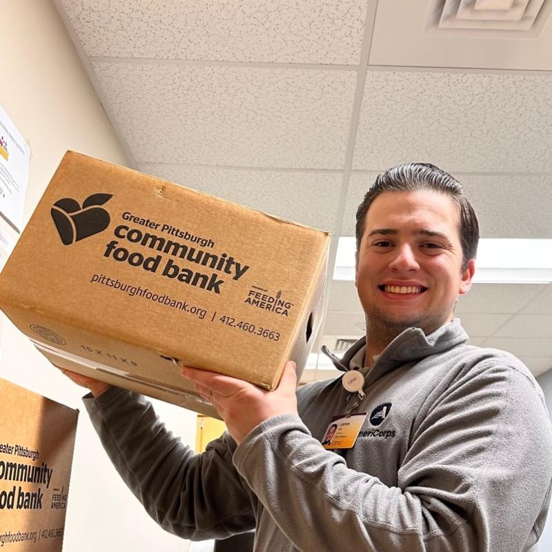 James is holding a food box.