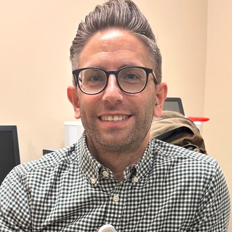 Joshua is sitting in an office.