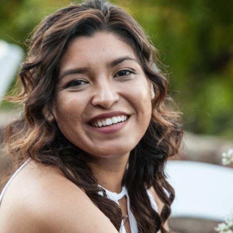 Maria Hower is seen facing the camera and smiling. 