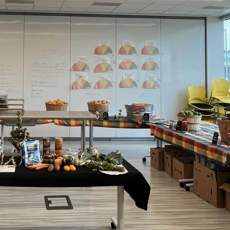 A Photo of the Food Pharmacy set up can be seen here. This includes tables in "U" formation with a variety of produce and ingredients, as well as a central table that shows a selection of what is available on that day. 