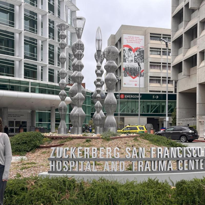 Morgan is standing next to a sign that reads Zuckerberg San Francisco General Hospital and Trauma Center.