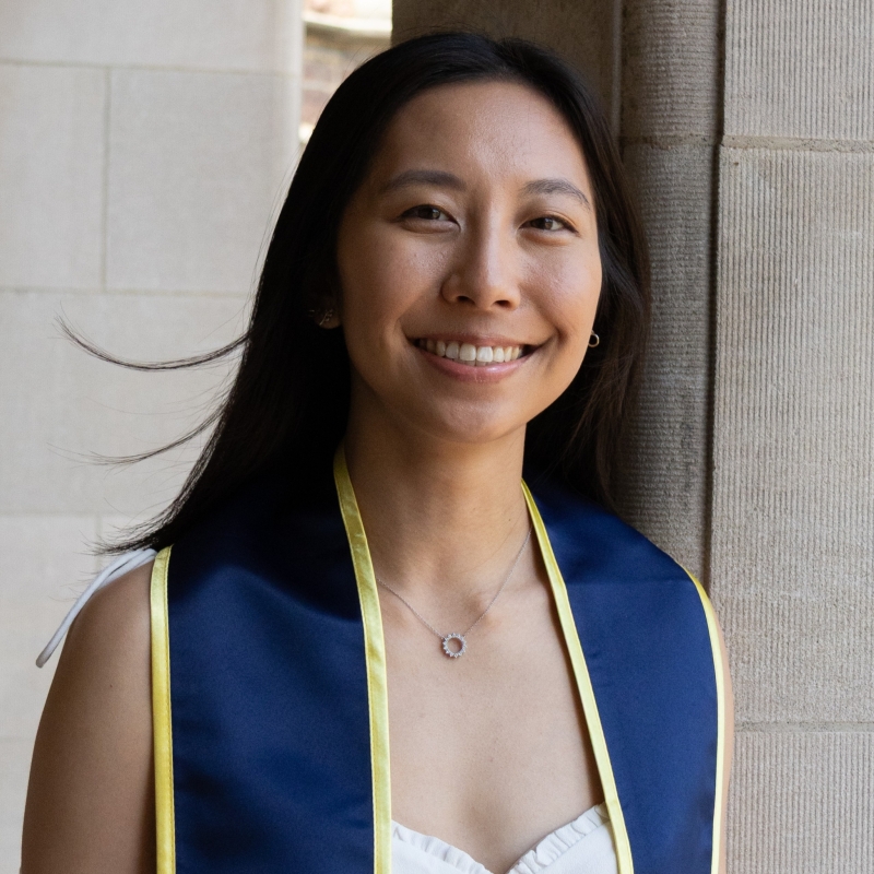 Kaylee smiling with blue graduation collar on