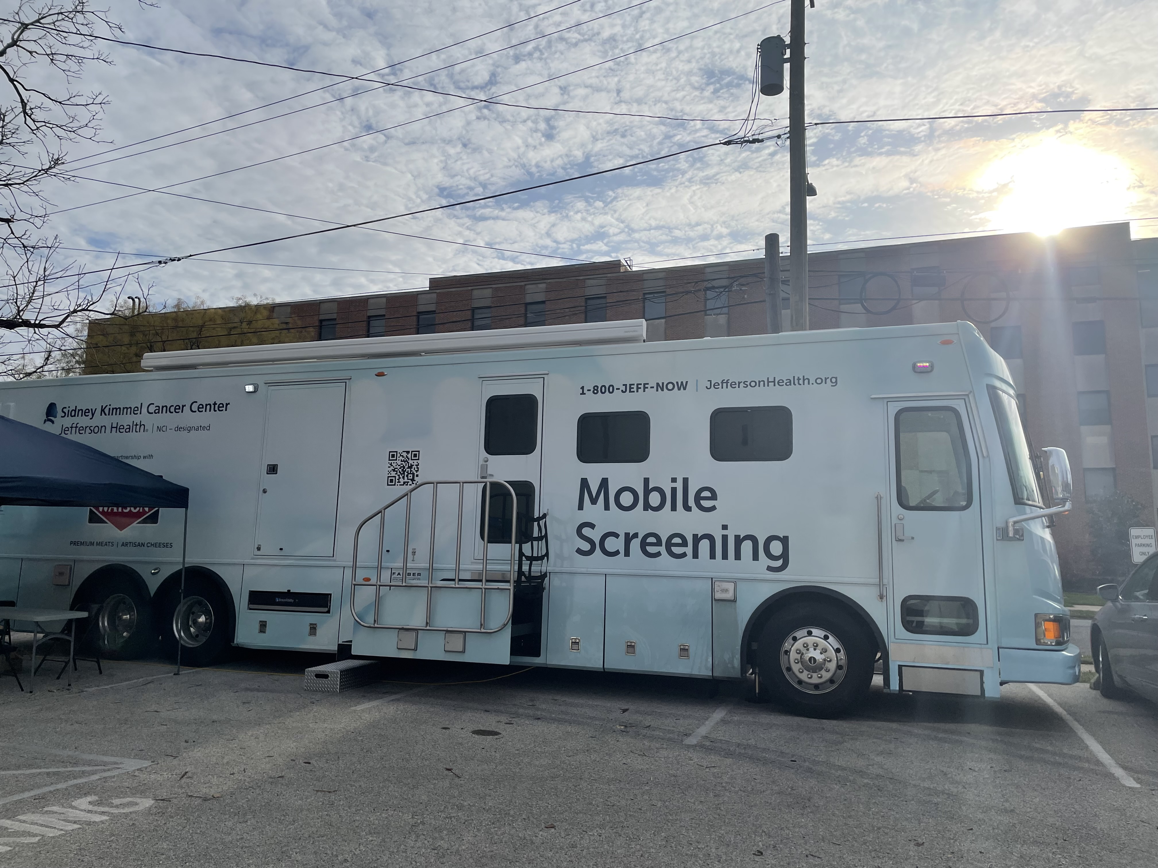 A large white van with the words "mobile screening" in a parking lot